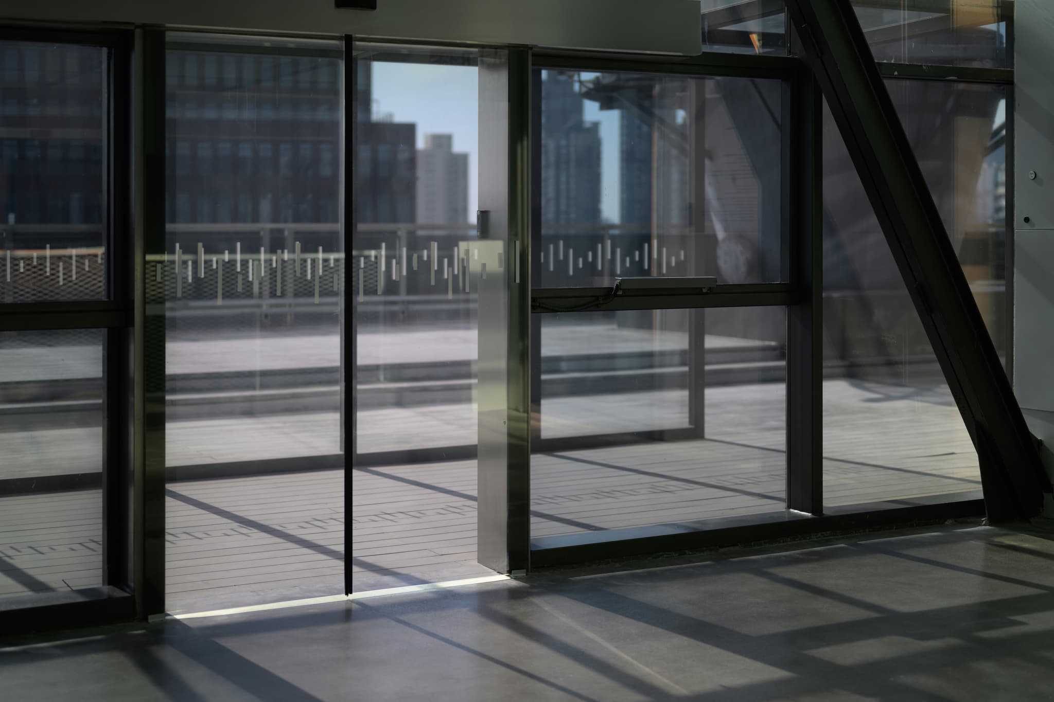 Automatic glass sliding doors at a commercial entrance with city skyline